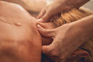 Top view of woman receiving shoulder massage from massage therapist.