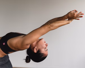 Yoga instructor stretching arms in studio.